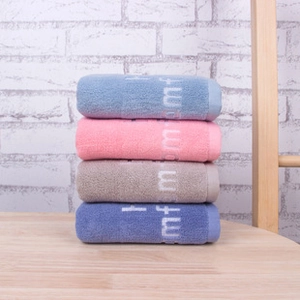 Close-up of four stacked microfiber makeup remover towels in blue, pink, and beige
