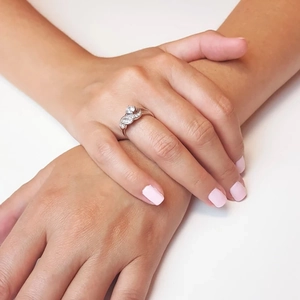 Gros plan d'une bague ailes d'ange en argent avec zircons sur une main