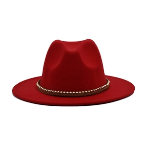 Λεπτομέρεια κόκκινου καπέλου fedora με καφέ πλεκτή κορδέλα και χρυσές χάντρες