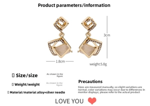 Detail showing 3cm x 1.8cm golden geometric earrings with cat eye stone and crystals