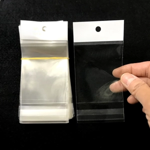 Detailed view of clear OPP plastic jewelry bags with white header and hanging hole design