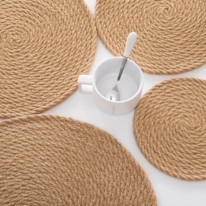 Handmade thick round jute heat-resistant placemats in various sizes on a white table
