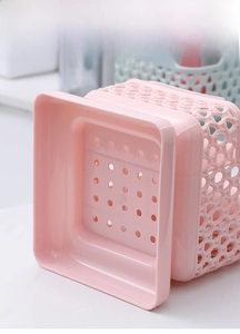 Detailed view of pink hollow storage bin featuring a hanging base and drainage holes