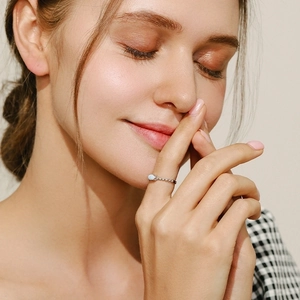 Elegant 925 sterling silver ring with opal and crystals worn by a smiling woman
