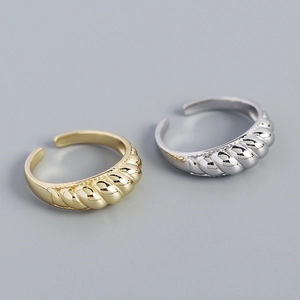 Detailed view of gold and silver S925 sterling silver rings with twisted croissant texture