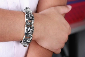 Detailed view of punk style skull bracelet in antique silver finish on male wrist