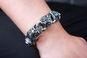Close-up of retro silver skull chain bracelet worn on wrist for a punk rock aesthetic