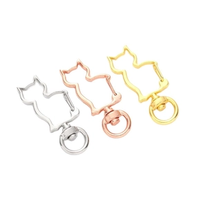 Set of three cat-shaped metal keychains in silver, rose gold, and gold on white background