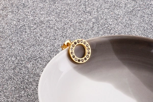 Macro detail of rose gold circle stud earrings featuring inset sparkling cubic zirconia
