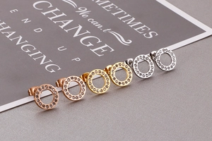 Close-up of rose gold, gold and silver hollow circular stud earrings with paved crystals