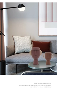 Dettaglio di vasi in ceramica a forma di viso in marrone e beige con manici dorati