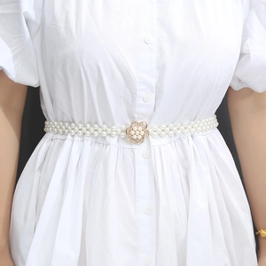 Detailed close-up of a double-row pearl waist belt with a gold flower rhinestone buckle