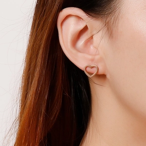 Fashionable minimalist hollow heart stud earrings in rose gold worn by a female model