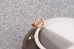 Close-up of rose gold hollow heart earrings featuring engraved LOVE lettering detail