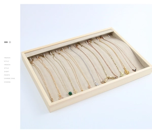 Macro view of wooden jewelry display tray with multiple hooks for elegant necklaces