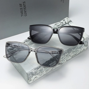 Classic black and transparent grey square sunglasses on an ice-textured stand
