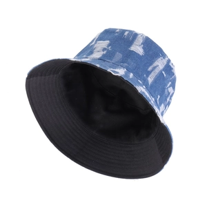 Distressed blue denim bucket hat with frayed details and reversible black fabric lining