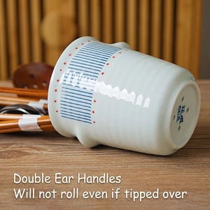 Japanese ceramic chopstick holder with blue stripes and anti-roll ear handles on wood