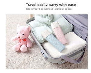 Detailed view of portable floral travel toothbrush cases in a suitcase with soft plush toy