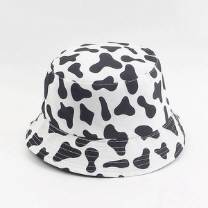 Vue détaillée d'un chapeau bob avec imprimé vache noir et blanc et coutures précises