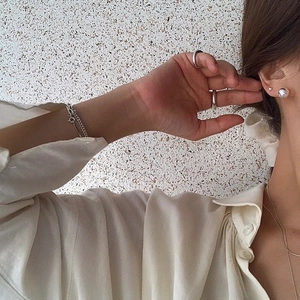 Minimalist sterling silver jewelry set featuring ball studs, rings, and necklaces on model