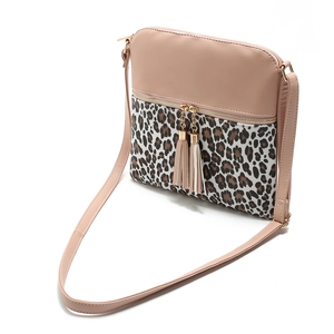 Detail view of pink crossbody bag with leopard print accent and double tassel charm