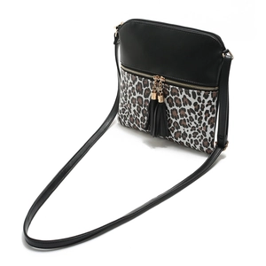 Detailed view of leopard print crossbody bag with double black tassel zipper pulls