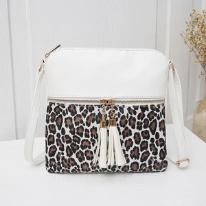 Detail of leopard print crossbody bag with white tassels and gold zipper close-up