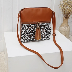 Detail of leopard print crossbody bag featuring double tassels and golden hardware