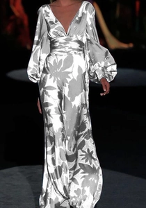 Detailed view of silver floral maxi dress with V-neck and lantern sleeves on runway