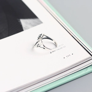 Close-up of handmade 925 sterling silver heart wire-wrapped ring on an open book