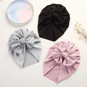 Detailed close-up of waffle texture baby turbans with large bows in black grey and pink