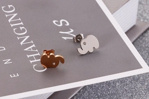 Macro shot of cute elephant stud earrings in rose gold and silver with zircon eyes