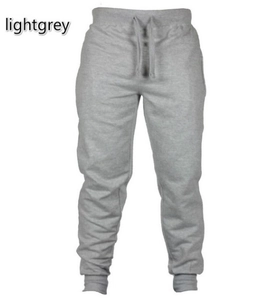 Detail view of light grey joggers featuring a drawstring elastic waist and ribbed cuffs