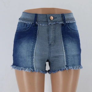 Détail de short en jean taille haute avec patchwork bicolore et ourlet à franges effiloché