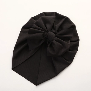 Detail shot of the large bow decoration on a soft black breathable baby turban hat