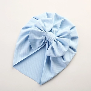 Detail of light blue baby turban hat with jacquard texture and large front bow