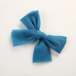 Detail view of blue mesh bow hair clip with layered tulle and solid color finish
