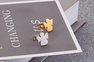 Macro detail of angel-shaped stainless steel stud earrings in gold and silver finish