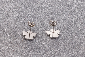 Macro shot of silver stainless steel angel wing earrings with needle back closure detail