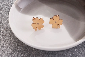 Detailed view of rose gold four-leaf clover stud earrings with a tiny center zircon