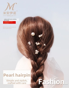 Detail of handcrafted pearl hairpins with manual wire wrapping in a braided hairstyle