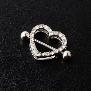 Silver heart-shaped nipple shield with sparkling crystals on black leather background