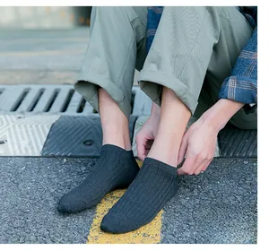 Detailed view of dark grey vertical ribbed knit ankle socks for men in outdoor setting