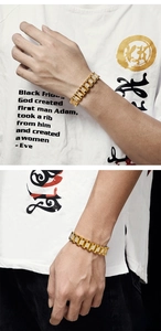 Macro detail of men's gold-plated H-link bracelet with micro-paved CZ stones for hip-hop style