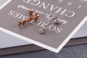 Detailed view of rose gold and silver fishbone heartbeat stainless steel stud earrings