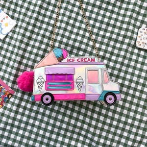 Detail of laser silver ice cream truck crossbody bag with pink pompom and gold chain