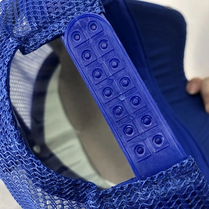 Detail of blue snapback hat showing the adjustable double-row plastic buckle and mesh
