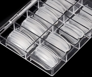 Macro shot of 100pcs clear plastic nail molds in various sizes in a storage box