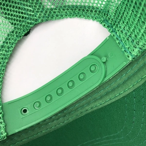 Close-up of the adjustable plastic snapback and breathable mesh on green baseball cap